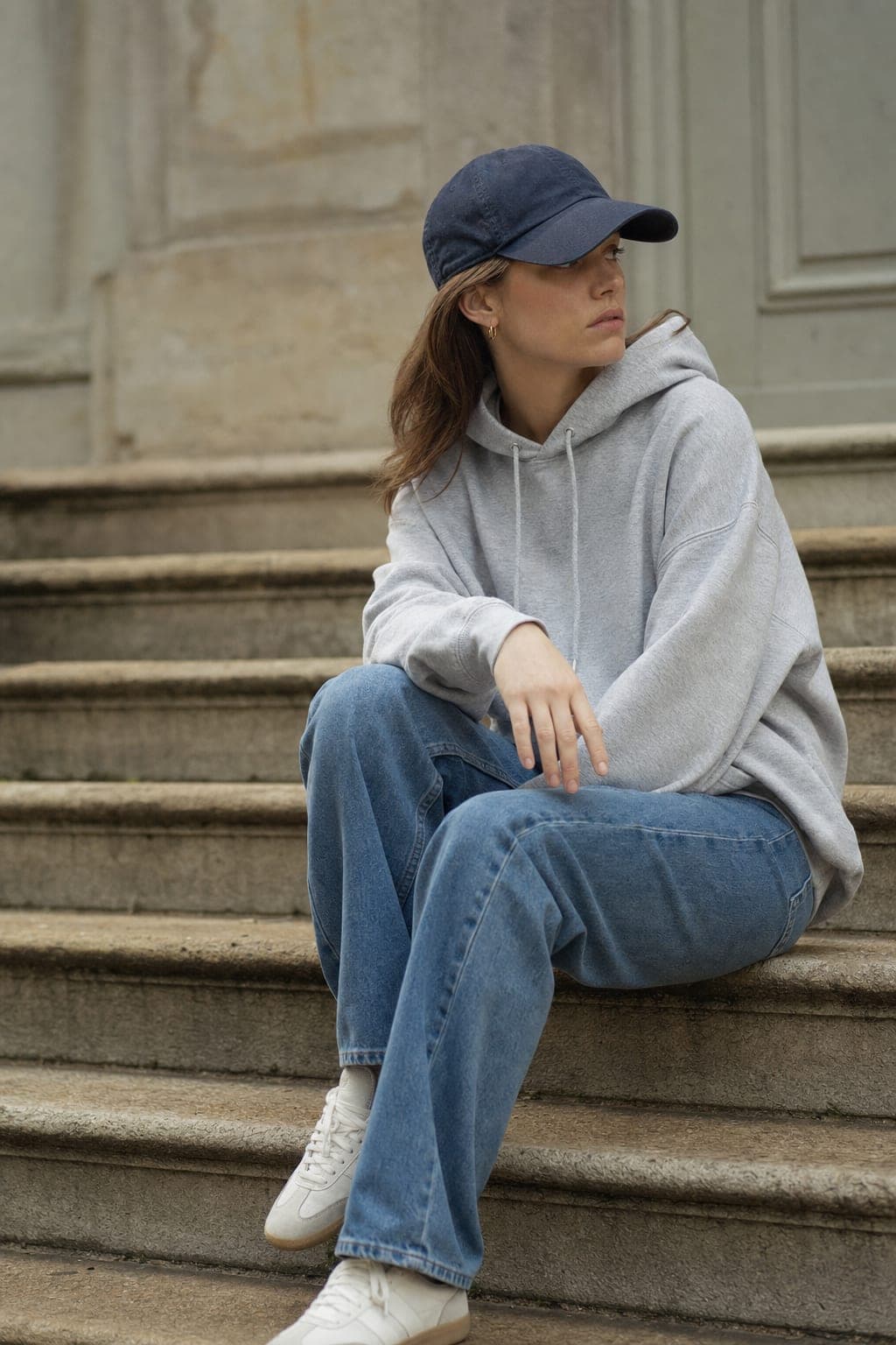 Casual normcore look with a plain hoodie, relaxed jeans, and a baseball cap